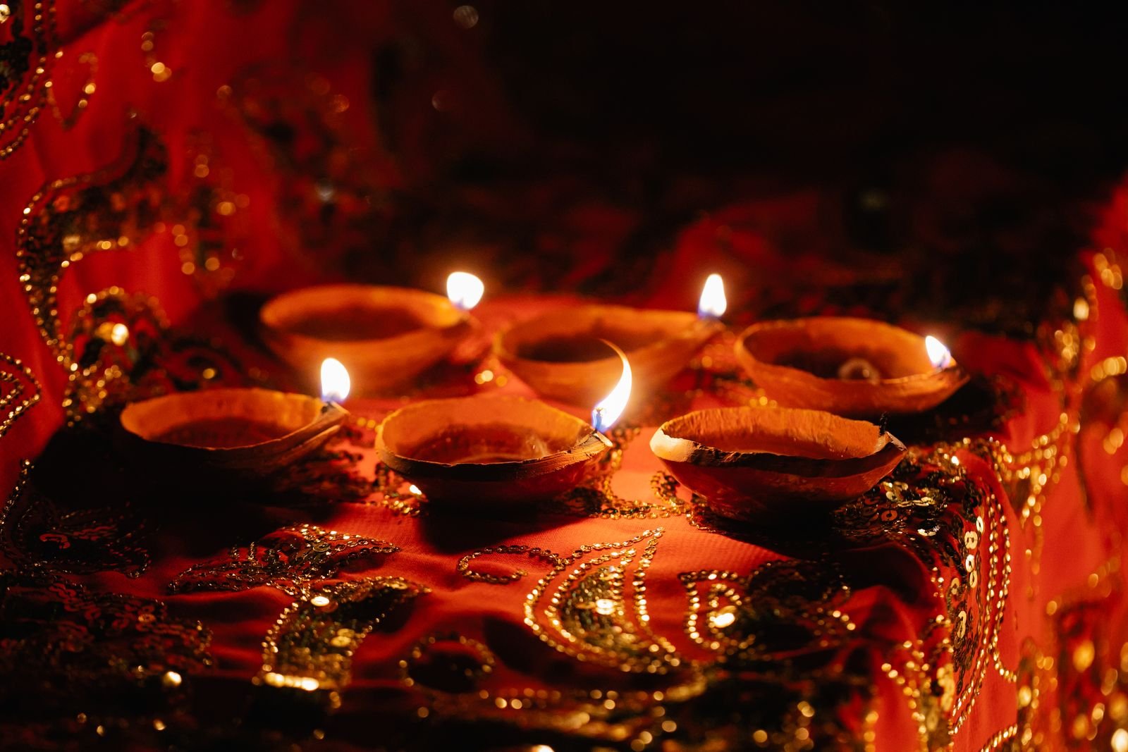 Diwali festive marketing for Indian small businesses — glowing diyas on red and gold fabric